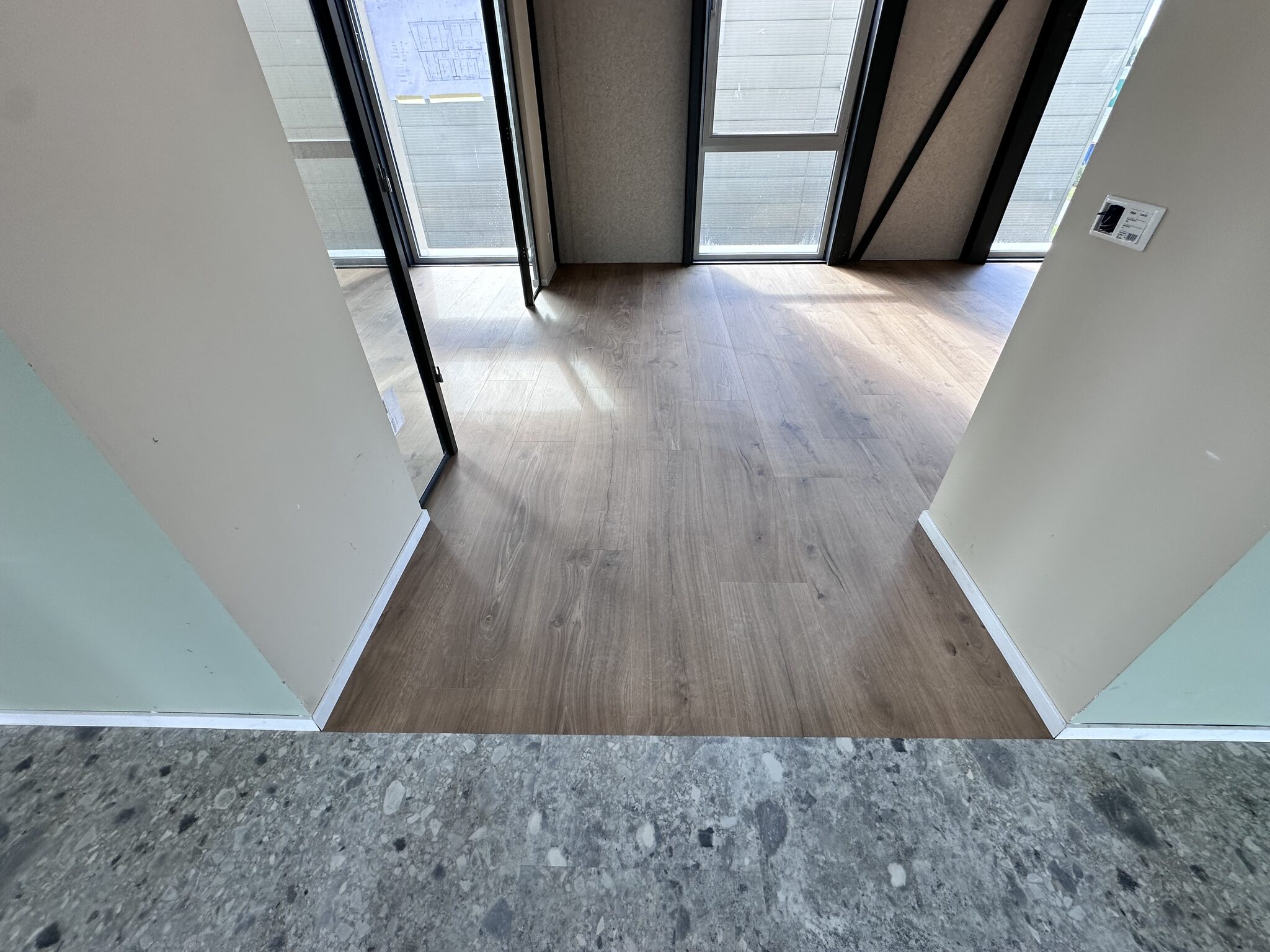 Overgang PVC terrazzo tegels naar houtlook planken in bedrijfspand Arnhem
